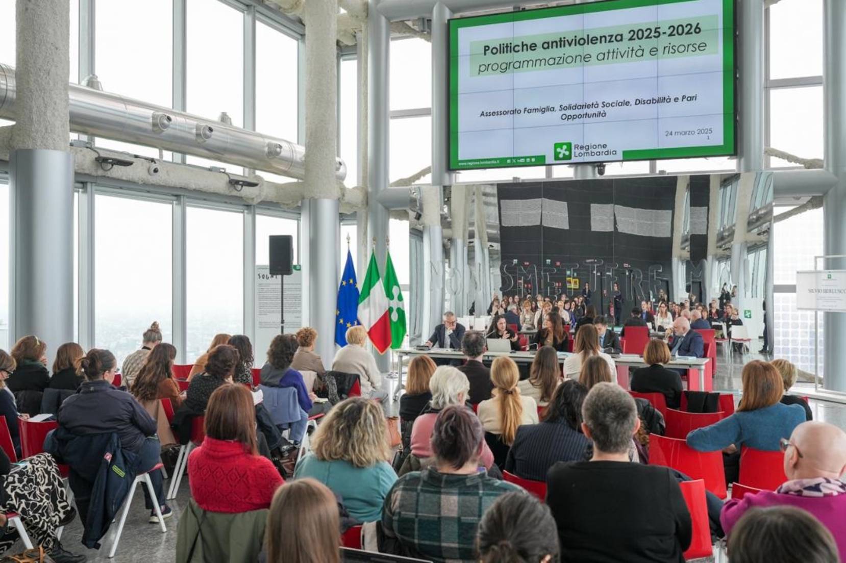 gruppo di persone sedute che assistono alla presentazione del piano regionale antiviolenza