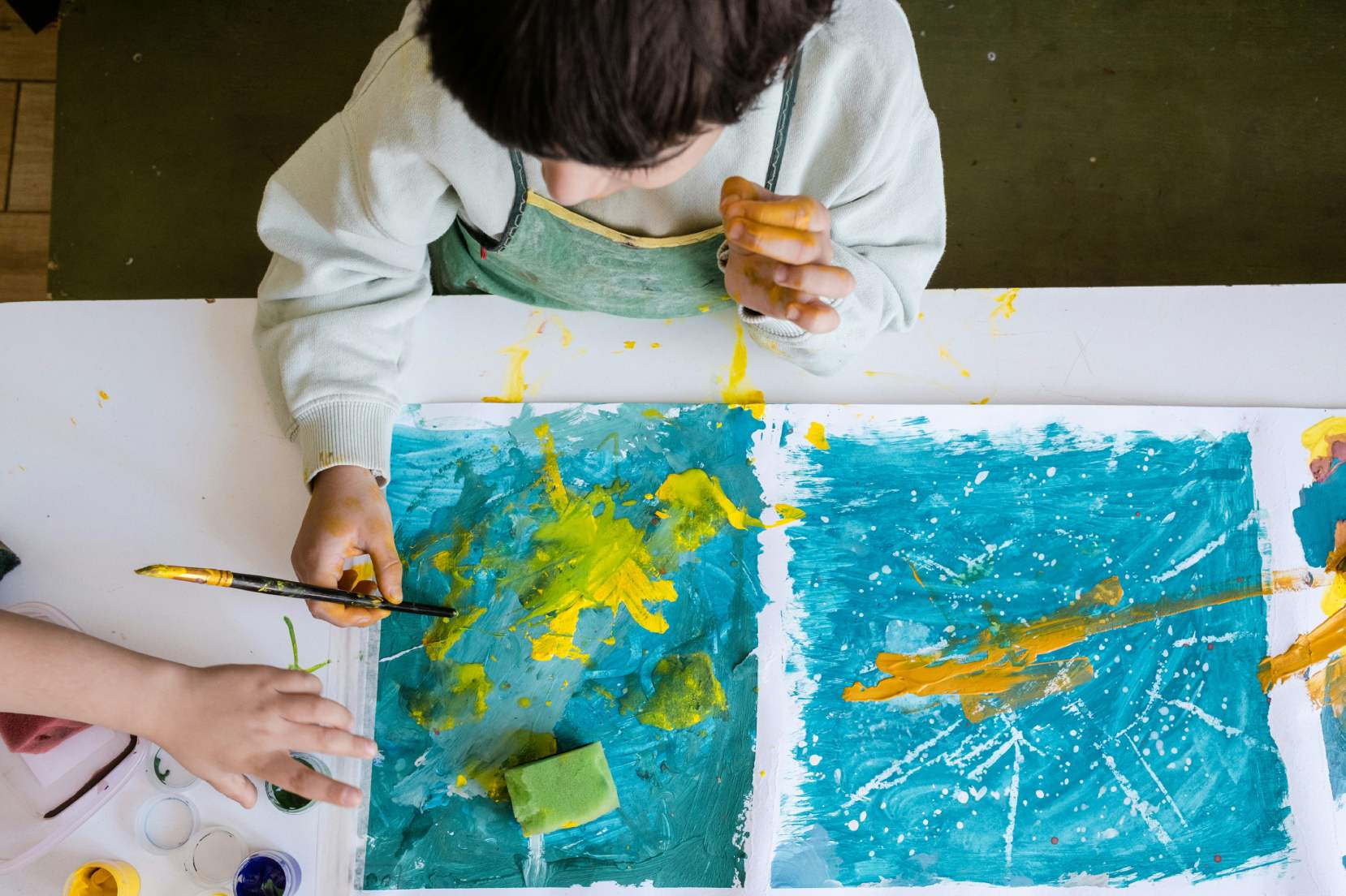 bambina che disegna con colori a tempera