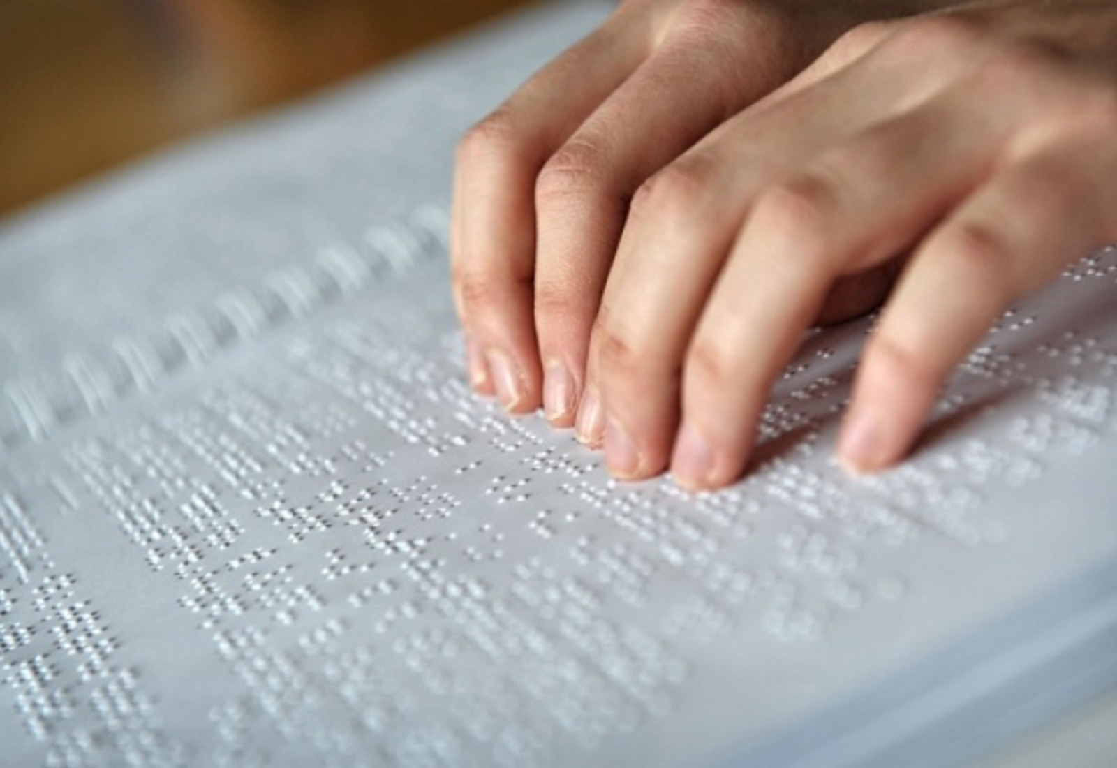 Mani che leggono Braille
