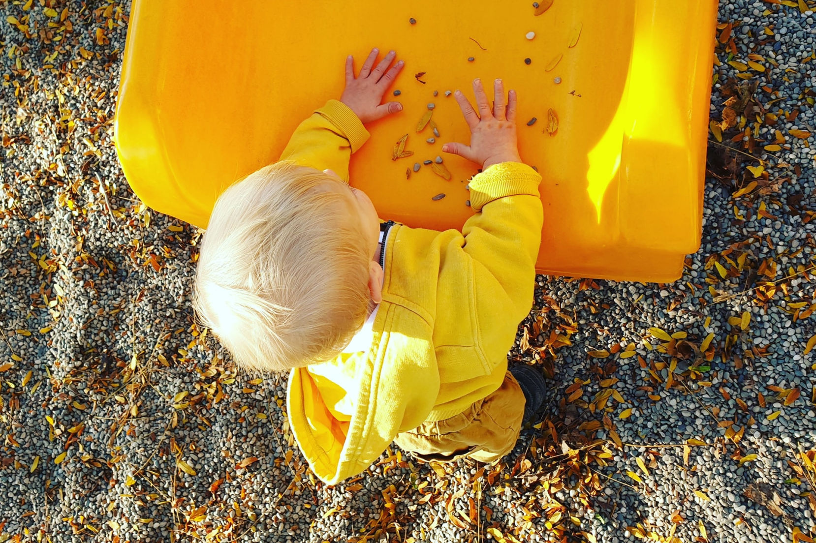 bambino che gioca vicino a uno scivolo giallo