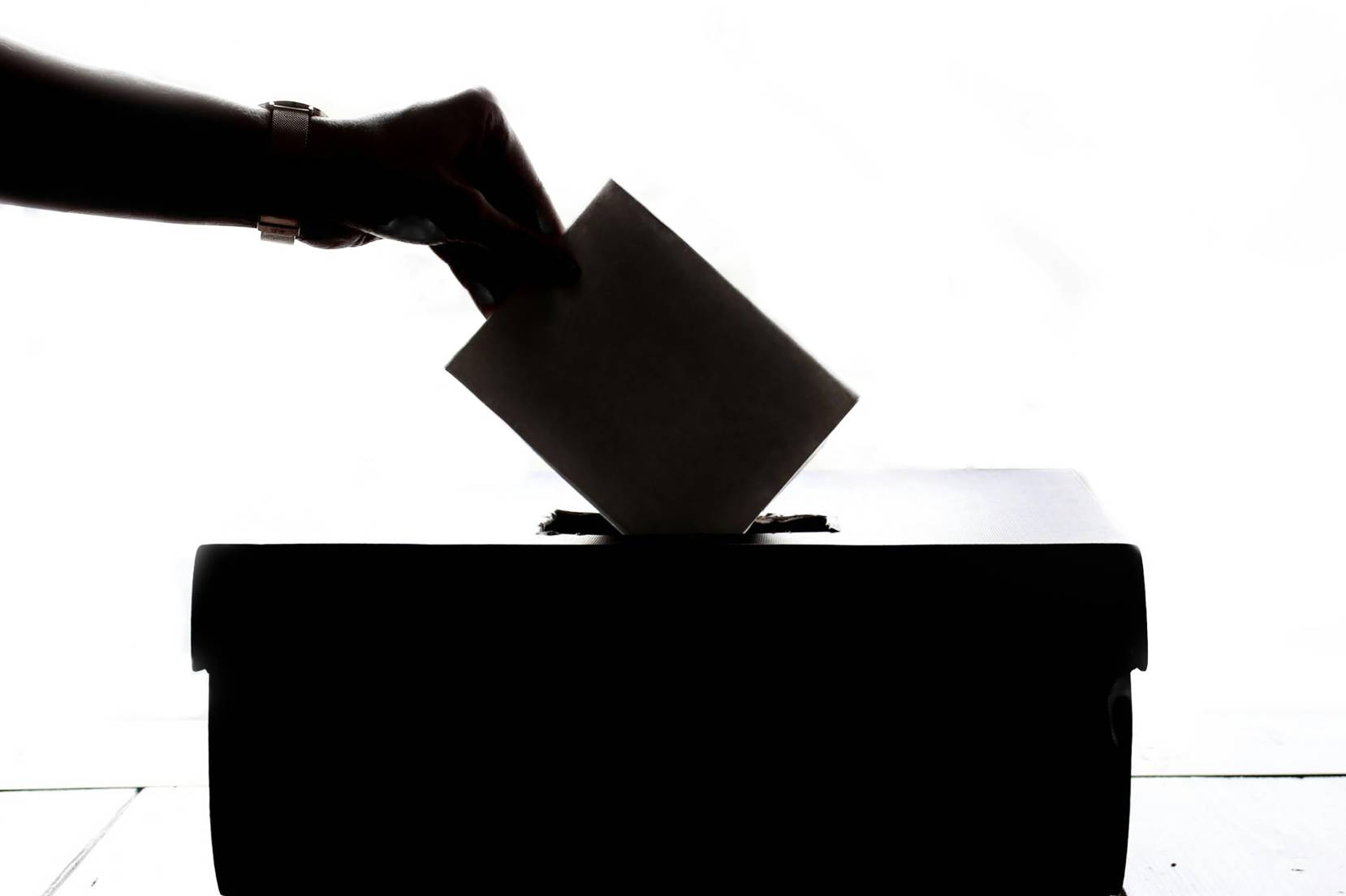 una persona inserisce una scheda elettorale nell'urna